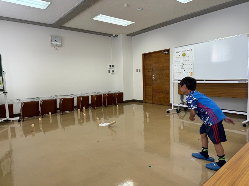 木のモルックを投げている